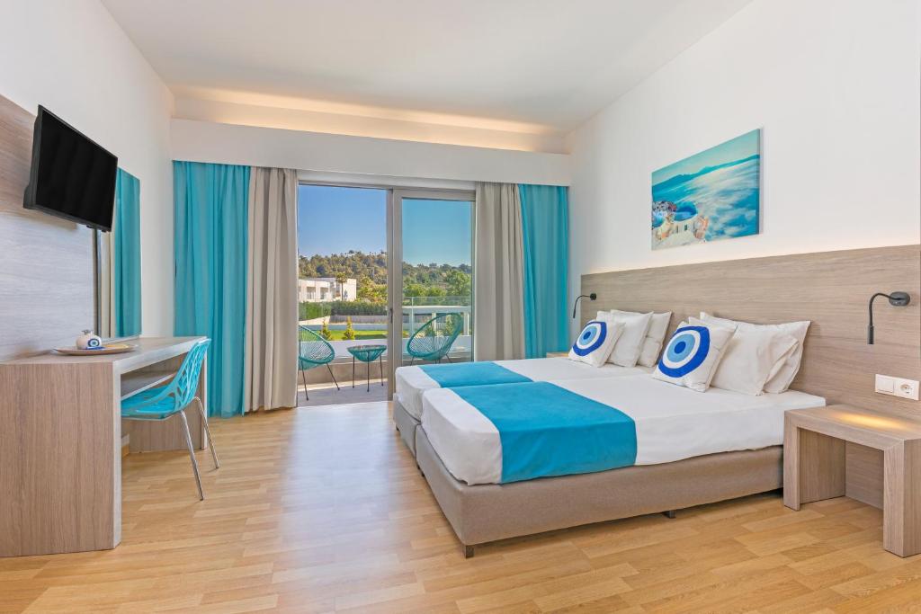 a bedroom with a bed and a desk and a television at Vergina Sun in Faliraki