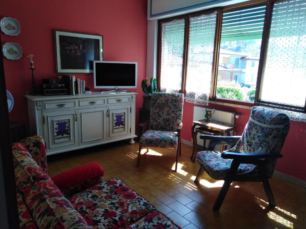 sala de estar con sofá, sillas y TV en Il semaforo Appartamento a due passi dal centro di Pietrasanta en Pietrasanta