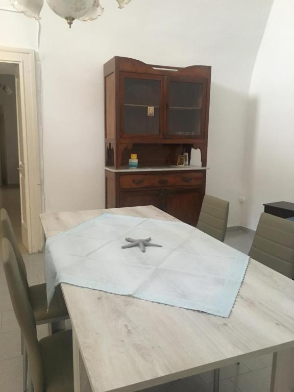 een houten tafel met stoelen en een houten kast bij Salento, casa tipica in Sternatia