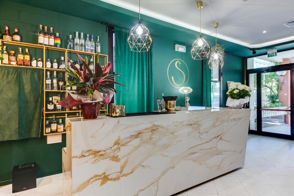 un bar con encimera de mármol en una habitación con paredes verdes en Hotel Sorriso, en Rímini