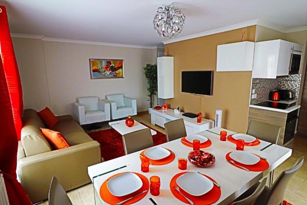 uma sala de estar com uma mesa e uma sala de estar com um sofá em Luxury Orange Paris Disneyland em Serris
