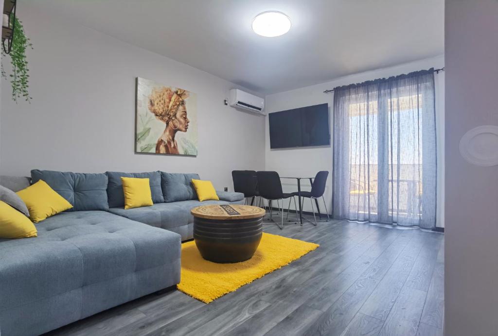 een woonkamer met een grijze bank en een geel tapijt bij Apartment PEK in Crikvenica