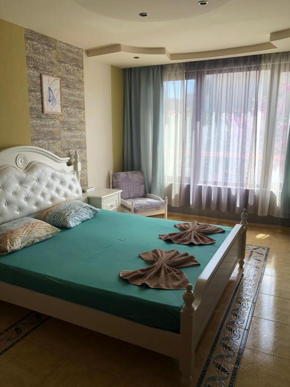 a bedroom with a large bed with two towels on it at Nesebar New Town Apartment in Nesebar