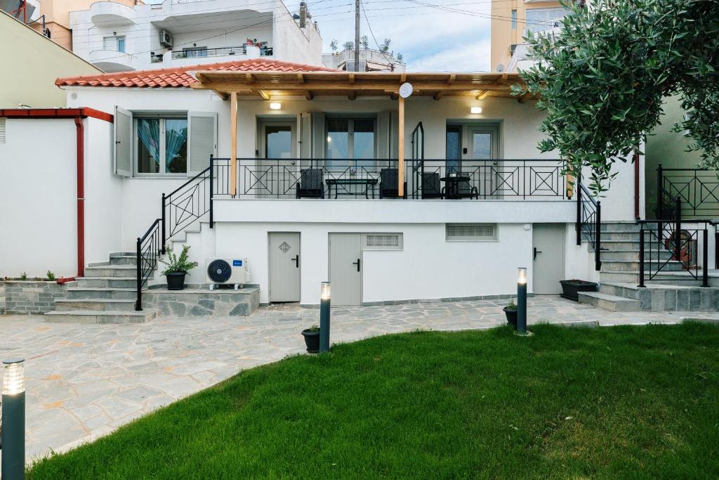 a large white house with a porch and stairs at Ilios house in Kavala