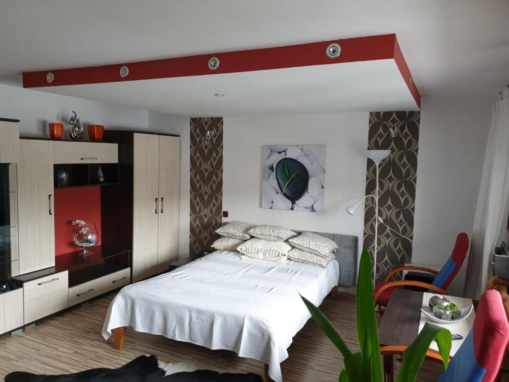 sypialnia z łóżkiem z białą pościelą i poduszkami w obiekcie słoneczne apartamenty w Krościenku