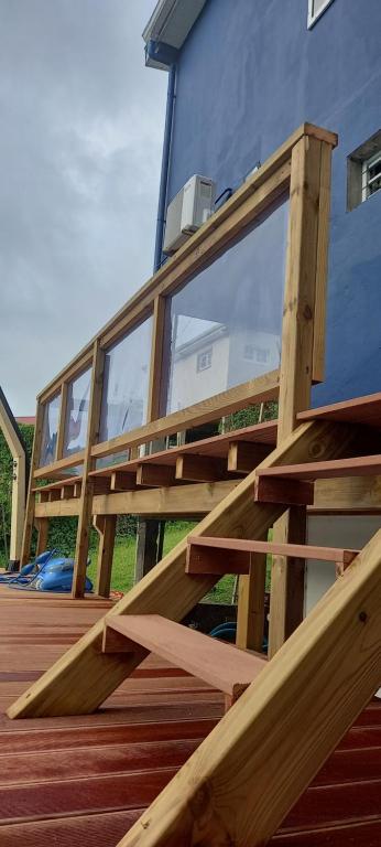 una terraza de madera con ventanas de cristal frente a un edificio en Serenity en Gros-Morne