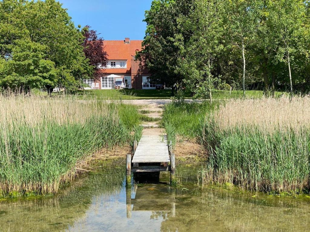 a wooden bridge in the middle of a pond at NTAB10001-FeWo-Moeoevwarder in Neue Tiefe Fehmarn