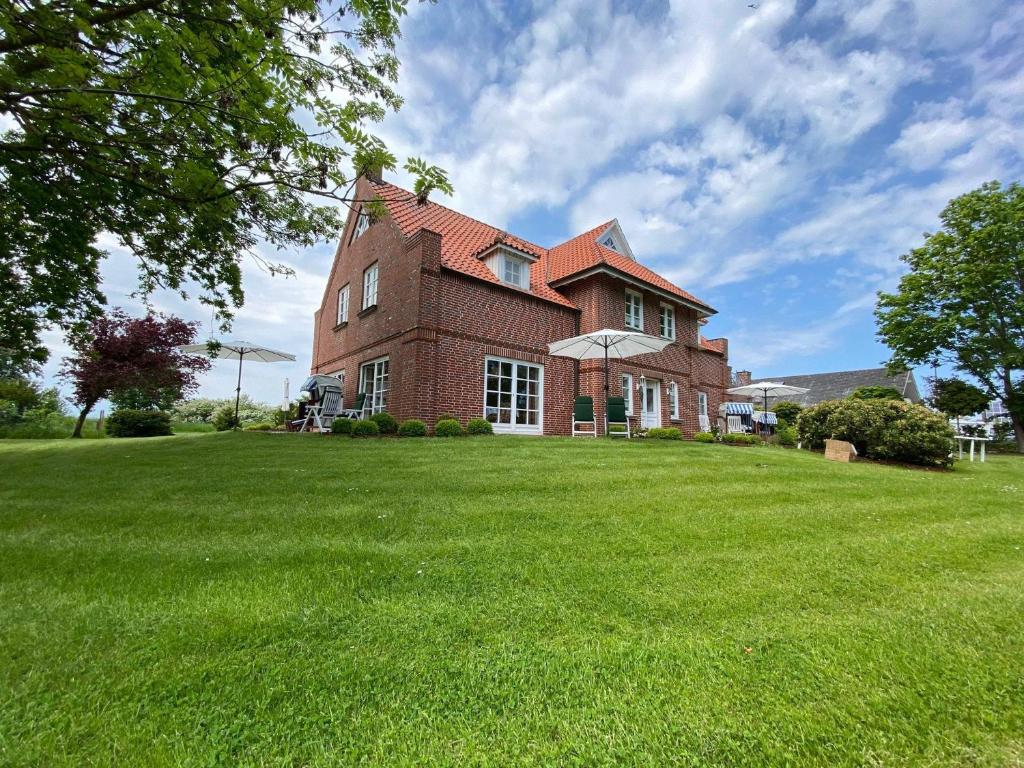 a large brick house with a green lawn at NTAB10104-FeWo-Moeoevwarder-veer in Neue Tiefe Fehmarn