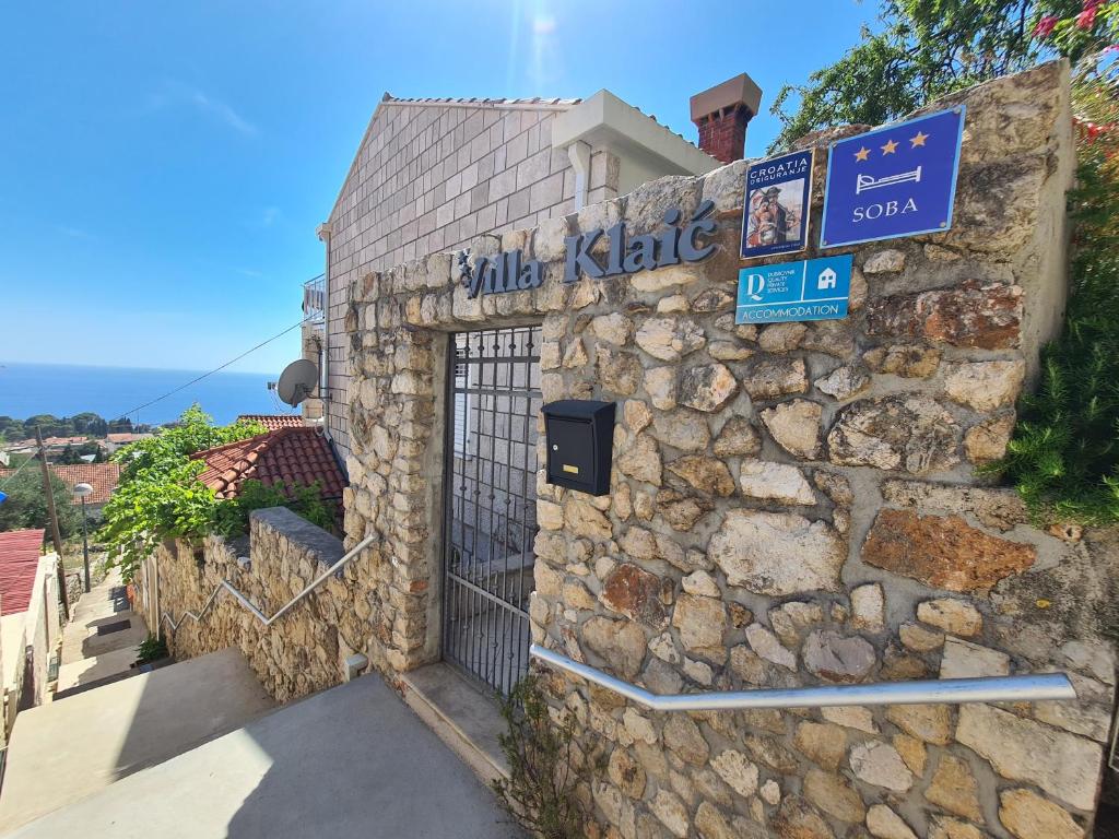 a stone building with a gate and a sign on it at Bed and Breakfast Villa Klaic in Dubrovnik