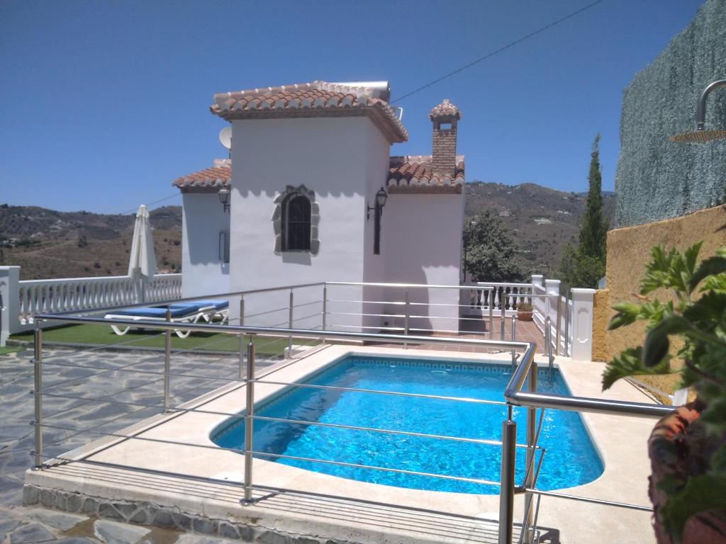 a villa with a swimming pool in front of a house at Villa Las Encinas COSTA DEL SOL in Torrox