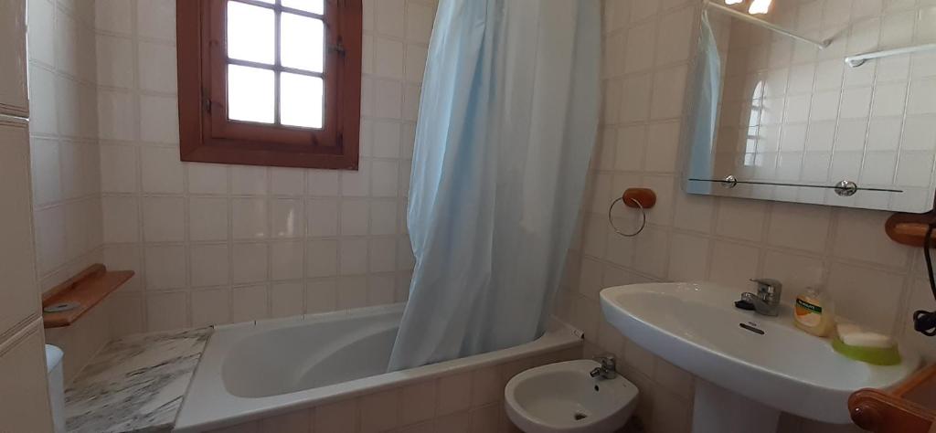 een badkamer met een wastafel, een bad en een toilet bij Apto POBLET by MENORCAHOST - Vistas únicas al mar en Playas de Fornells in Es Mercadal