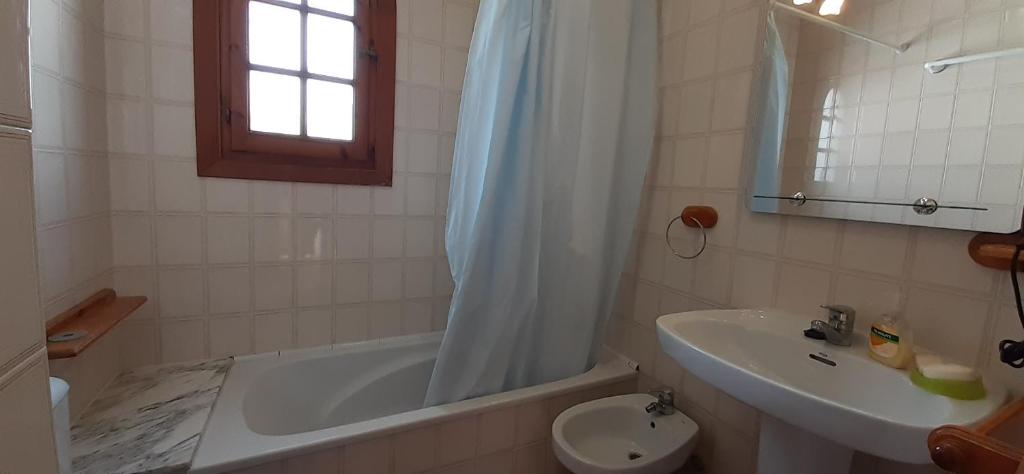 a bathroom with a sink and a tub and a toilet at Apto POBLET by MENORCAHOST - Vistas únicas al mar en Playas de Fornells in Es Mercadal