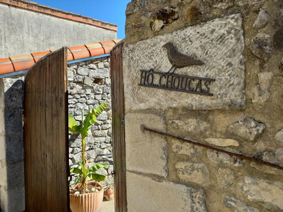 un panneau sur un mur de pierre avec un oiseau sur celui-ci dans l'établissement hô choucas, à Chauvigny