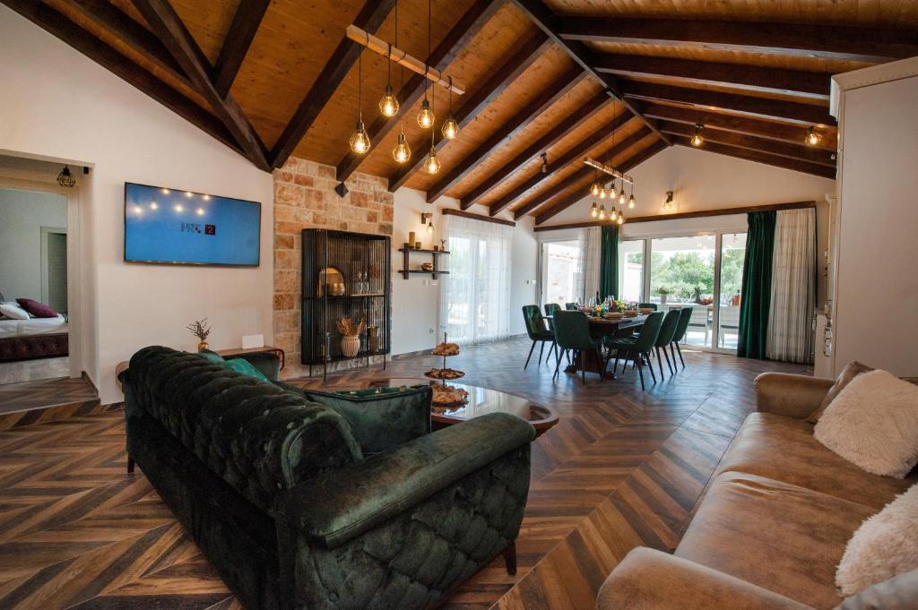 a living room with a couch and a table at Luxury Villa Nature with heated private pool, sauna & fire pit, a short walk to the beach in Milna