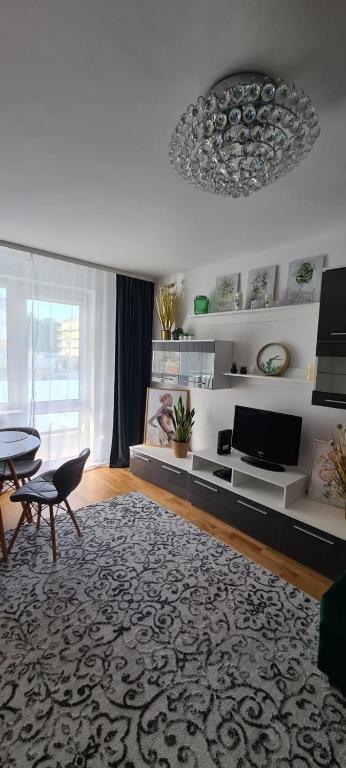 un salon avec une table et une télévision dans l'établissement Apartament na wydmie u Eli, à Ustka