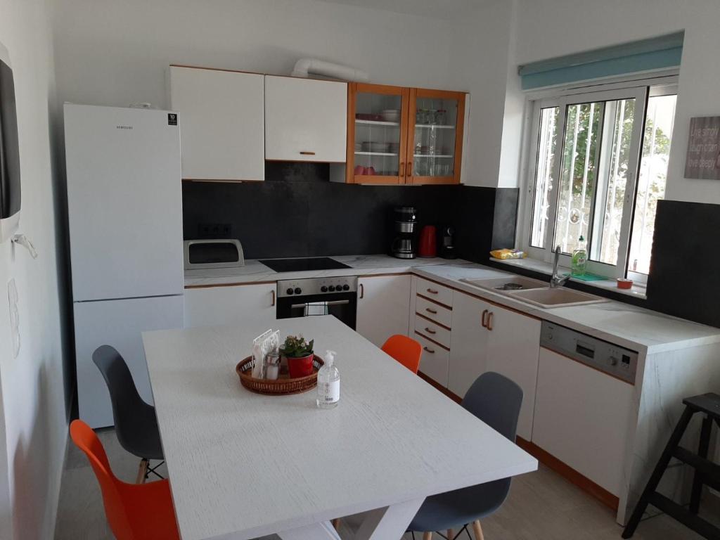 une cuisine avec une table blanche, une table et des chaises dans l'établissement My holiday home, à Rhodes