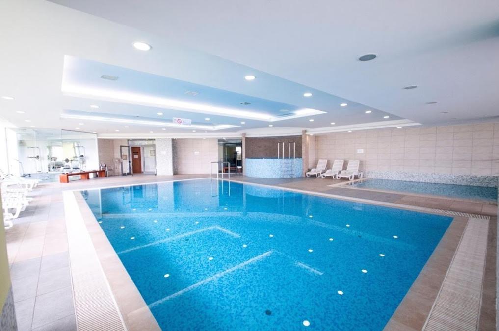 a large swimming pool in a hotel room at Panoráma Gold Wellness Apartman in Siófok