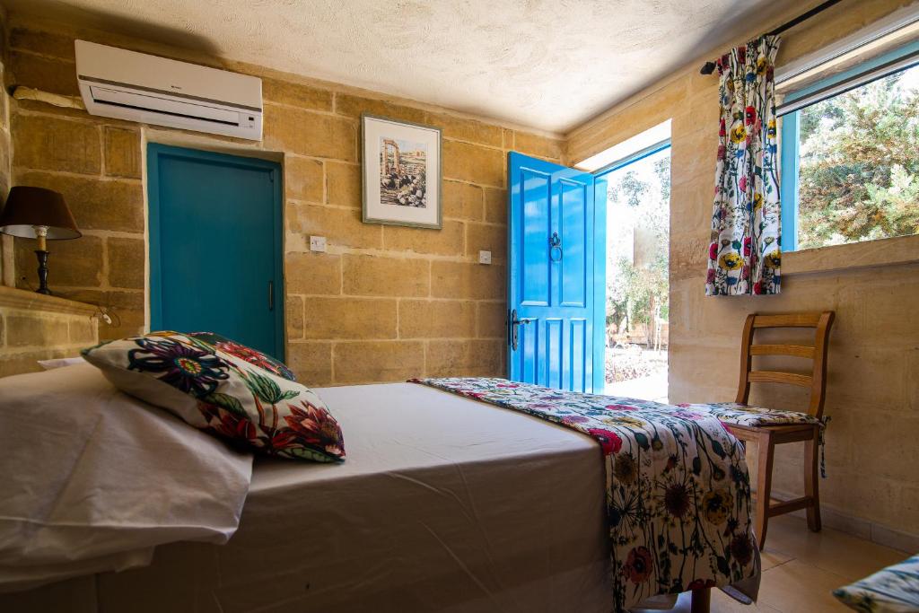 a bedroom with a bed and a blue door at Ta' Bertu Host Family Bed & Breakfast in Ħal Far