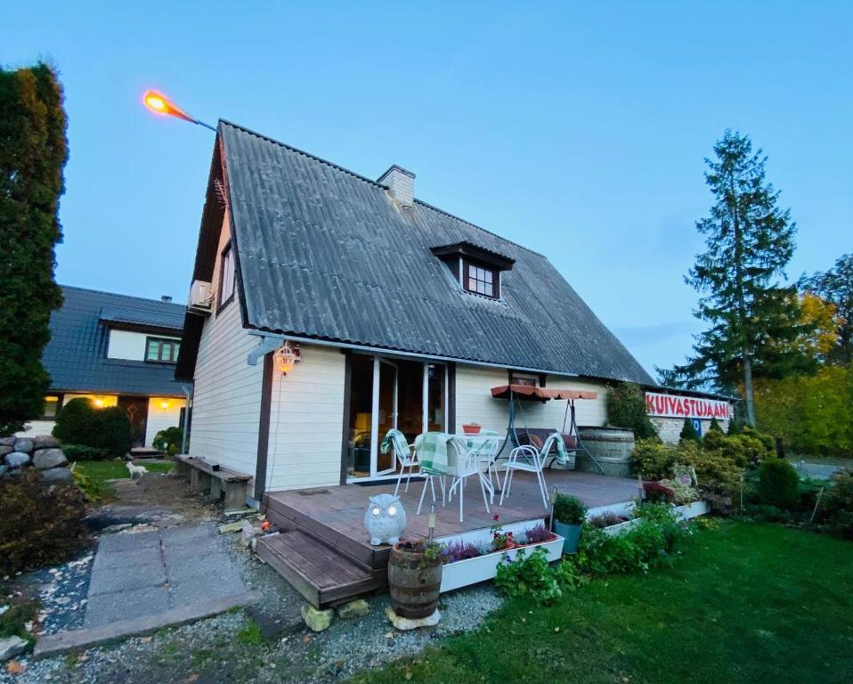 een klein wit huis met een veranda en stoelen bij Kuivastujaani in Kuivastu