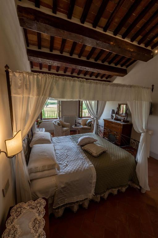 sypialnia z dużym łóżkiem z baldachimem w obiekcie Agriturismo Castello La Grancia di Spedaletto w mieście Pienza
