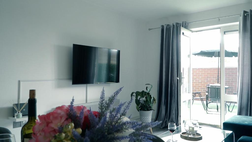 sala de estar con TV en la pared en Blue Apartment, 2 Bedroom with Balcony, Netflix, en Peterborough