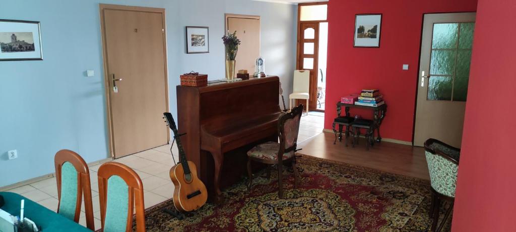 a living room with a piano and a guitar at Pokoje i kwatery w Augustowie in Augustów