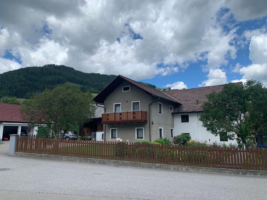 a house with a wooden fence in front of it at FeWo Lüttich in Etmissl