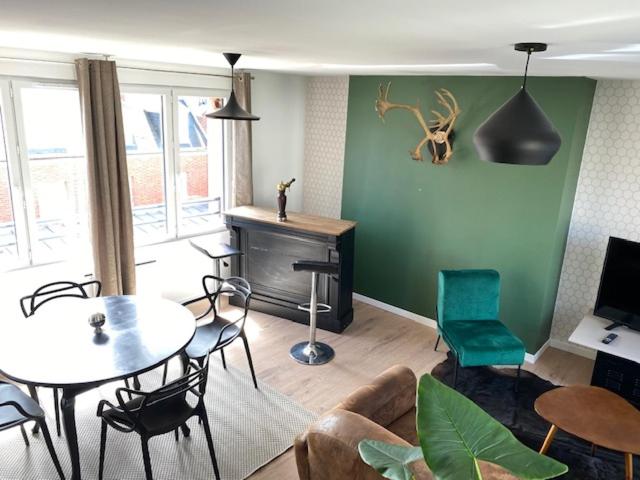 a living room with a table and chairs at duplex proche gare vue tour Perret avec parking gratuit in Amiens