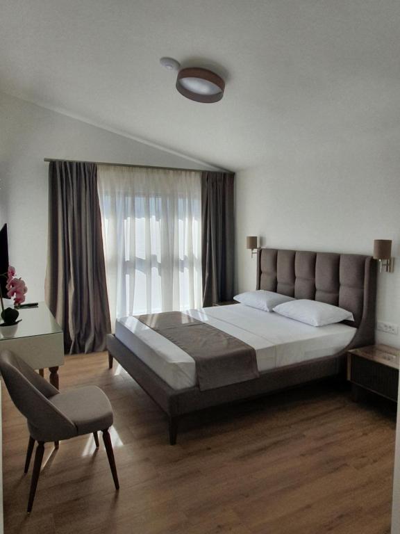 a bedroom with a large bed and a chair at Apartments Boreta in Budva