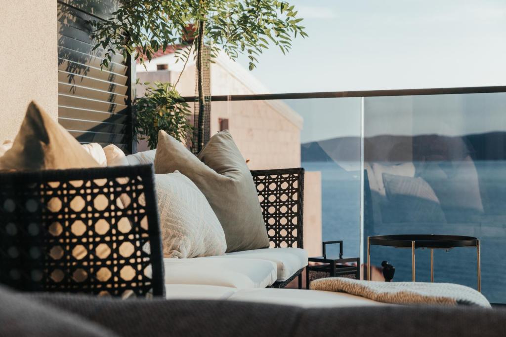 a white couch sitting on a balcony with pillows at Apartment 1911 in Brela