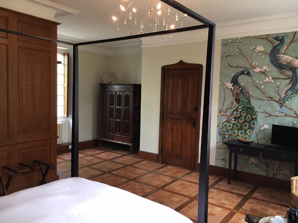 a bedroom with a bed with a large mirror at LA MEFFRAIS 1741 in Dinan