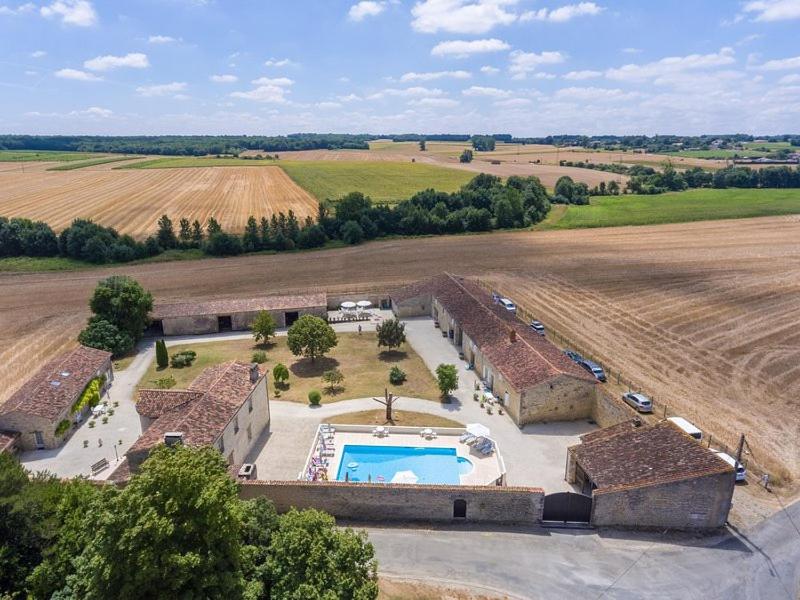une vue aérienne sur un bâtiment avec une piscine dans un champ dans l'établissement Le Vieux Monastere, à Saint-Hilaire-de-Villefranche