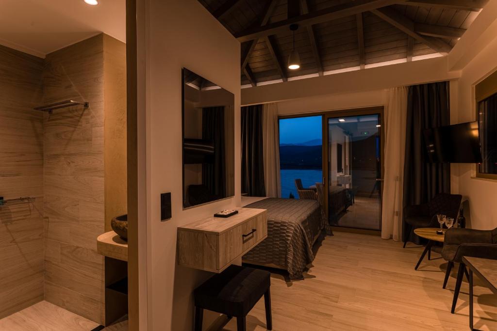a bedroom with a bed and a bathroom with a view at Lighthouse Apartments in Stoupa