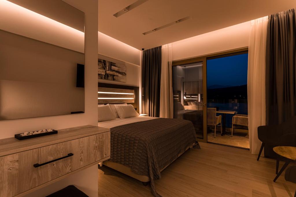 a bedroom with a bed and a large television at Lighthouse Apartments in Stoupa
