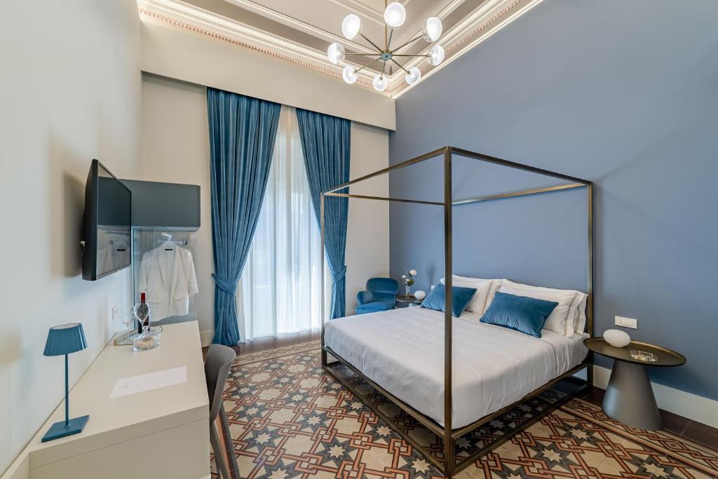 a bedroom with a canopy bed and blue walls at Ciuri di Strata in Catania