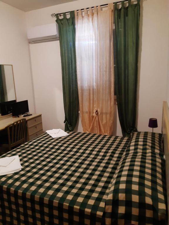 a bedroom with a bed with a checkered blanket at Hotel Mercede 2 in San Felice Circeo