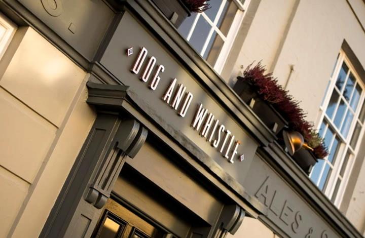 una señal en el lateral de un edificio en Dog and Whistle Pub, en Hertford