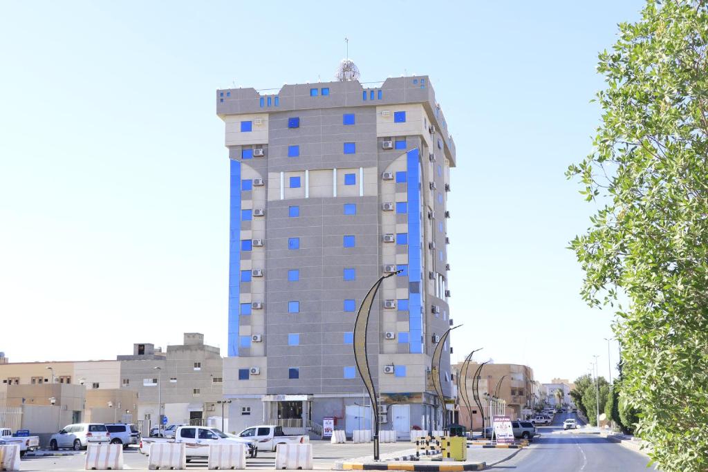 a tall building with blue windows on a city street at Al Farhan Dumah Al Jandal in Dawmat al Jandal