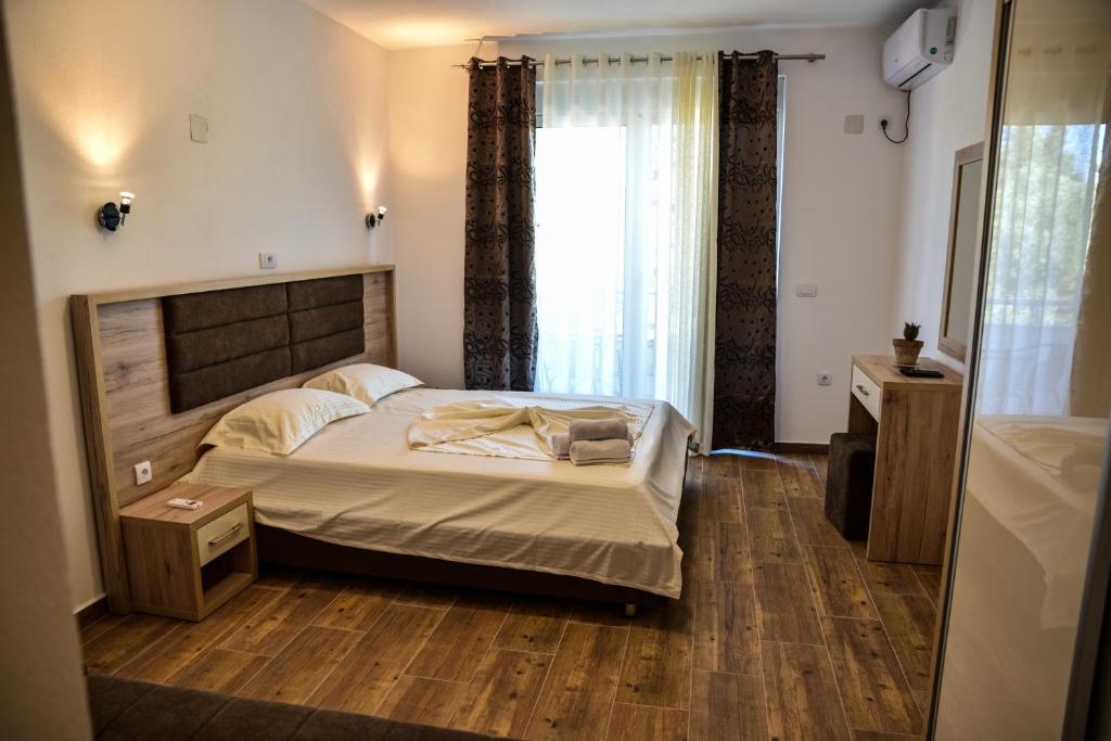 a bedroom with a bed and a large window at Casa Sinani in Ulcinj