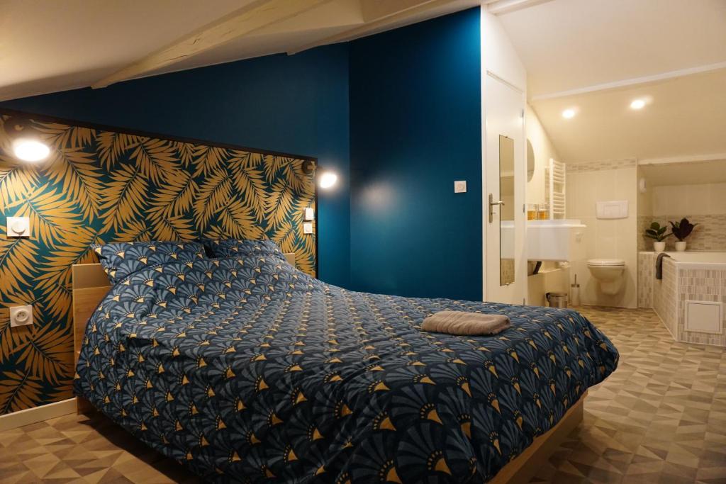 Schlafzimmer mit einem Bett mit blauer Wand in der Unterkunft Appart Cosy 4 personnes avec terrasse in La Roche-sur-Yon