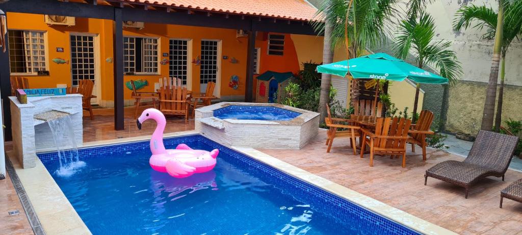 a pink swan in a swimming pool next to a house at Pousada Sao Paulo in Vila Muriqui