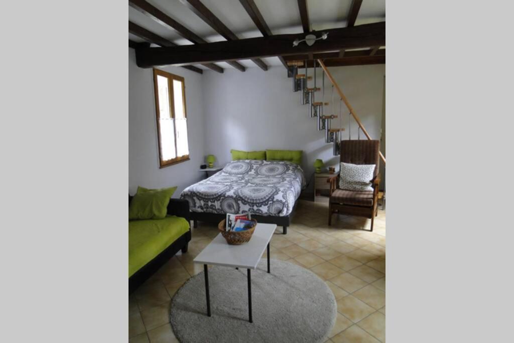 ein Wohnzimmer mit einem Bett und einem grünen Sofa in der Unterkunft Miller's farm. Cottage on the Auhtie for 2 in Hem-Hardinval