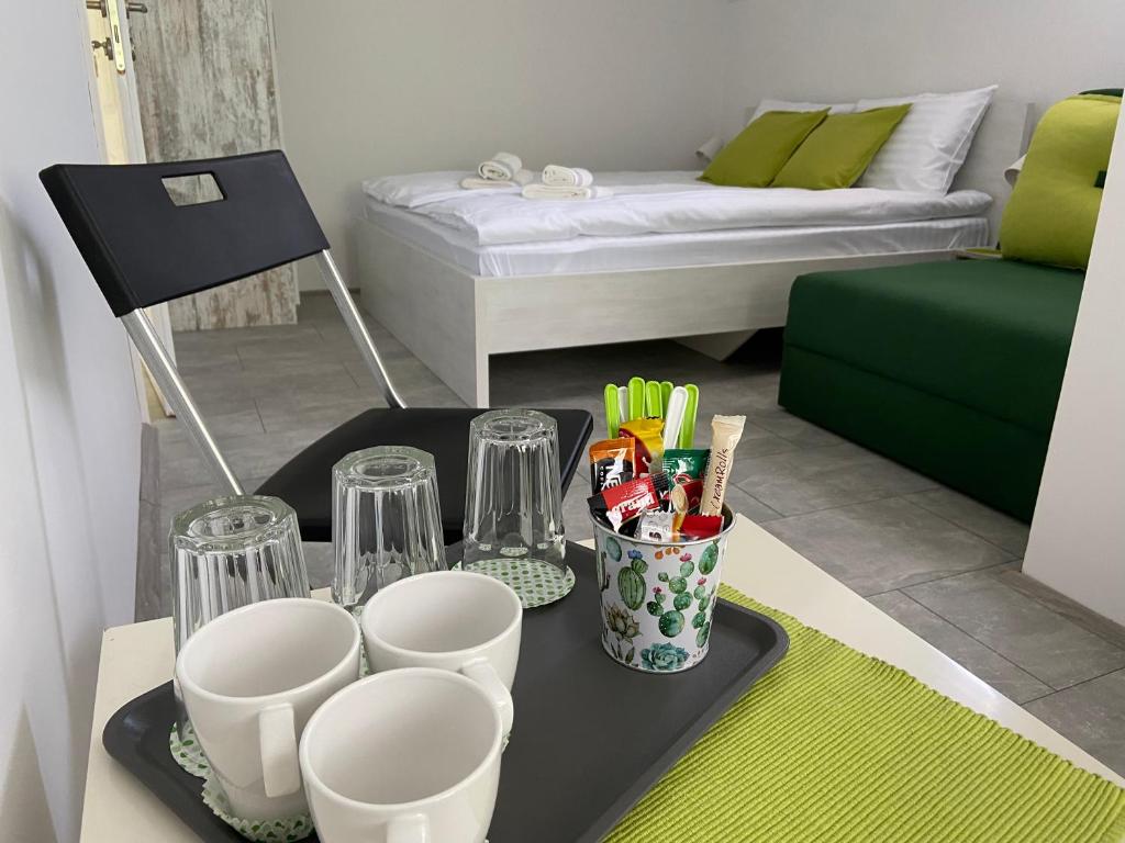uma mesa com uma bandeja com copos e utensílios em OMIS Rooms em Pančevo