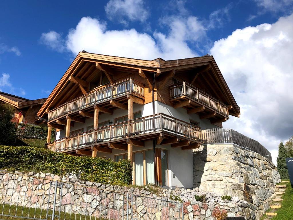 a wooden house with balconies on top of a stone wall at Chalet Bergzeit in Seefeld in Tirol