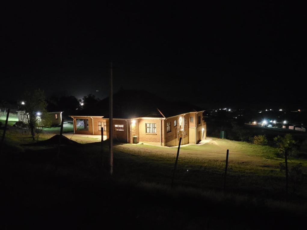 uma pequena casa à noite com as luzes acesas em KwaNomzi Botique Lodge em Lusikisiki
