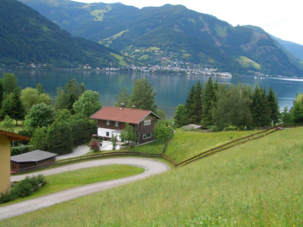 a house on a hill next to a lake at Villa Erlberg am See in Zell am See