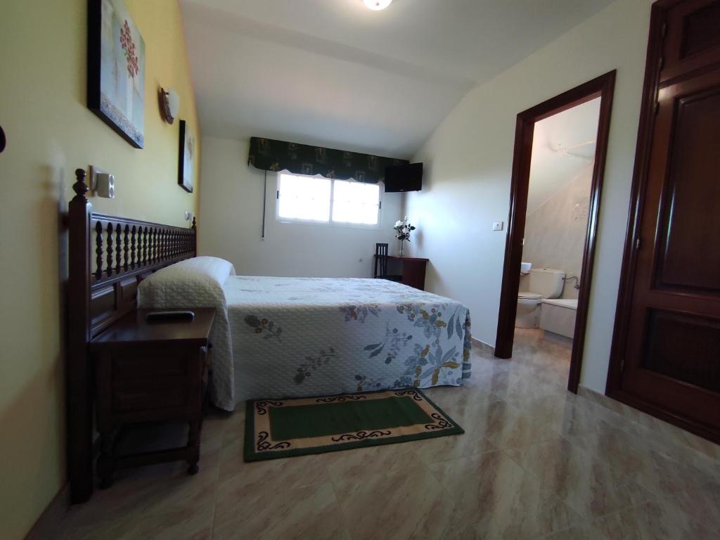 a bedroom with a bed and a bathroom at Pension Casa Carmela in A Lanzada