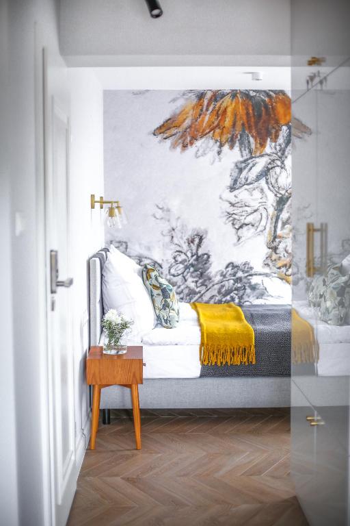 a bedroom with a bed with a painting on the wall at Zielony Dom in Mielno
