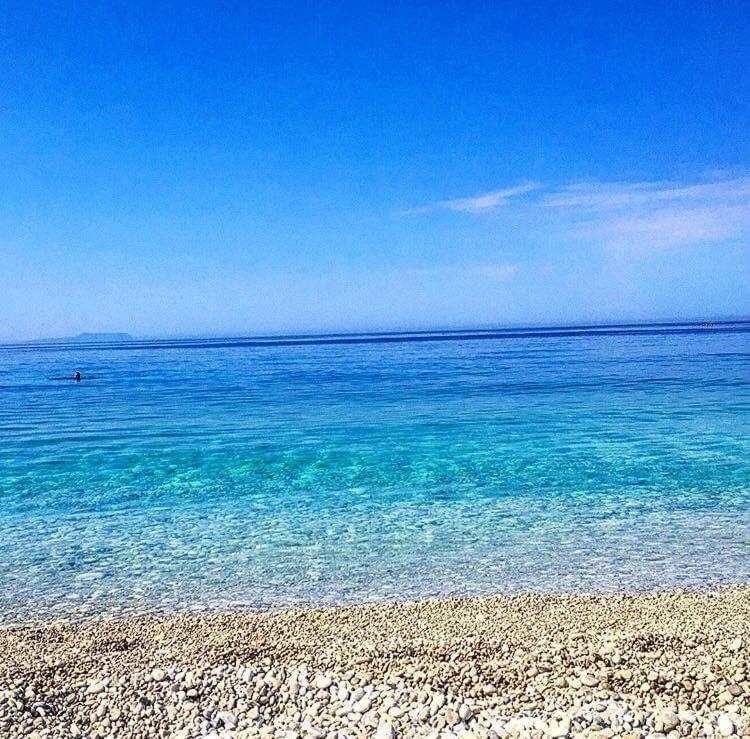 una playa con aguas cristalinas y una orilla rocosa en Villa John, en Borsh