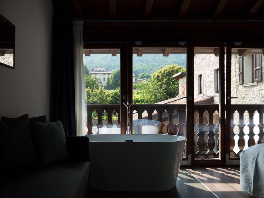 una vasca da bagno in una stanza con finestra di La terrazza sulle vigne B&B a Corte Franca